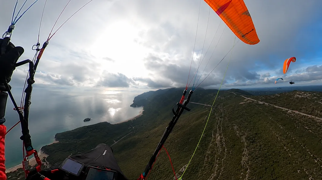 Paragliders above the Arrábida sea cliffs