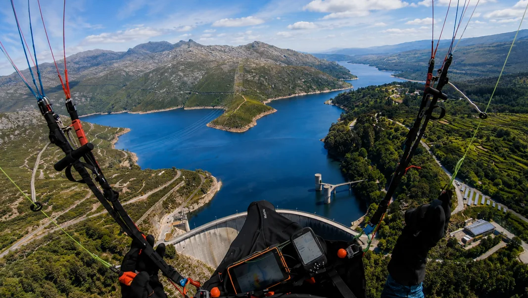 Paraglider cockpit view over the blue reservoir and dam of Peneda-Geres