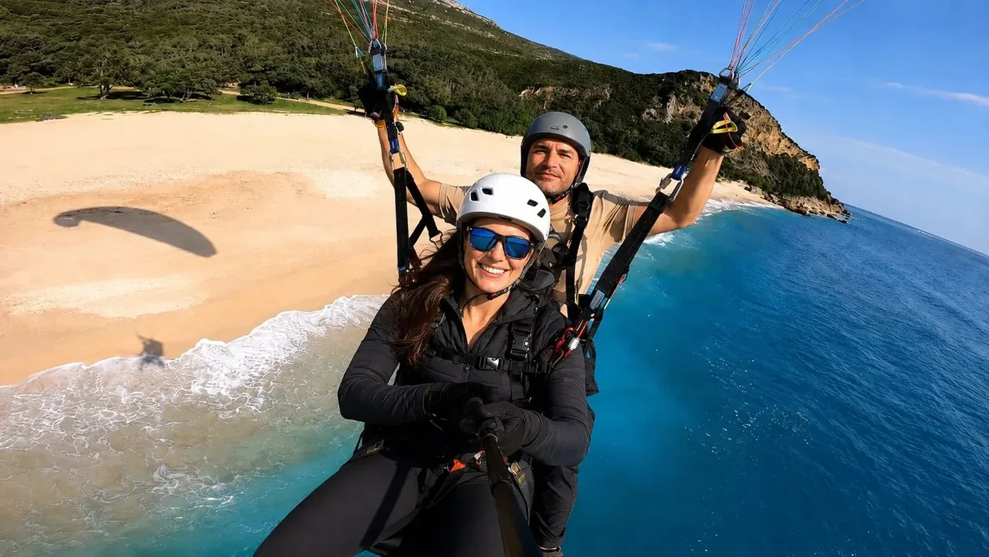 Tandem paragliding above a turquoise beach