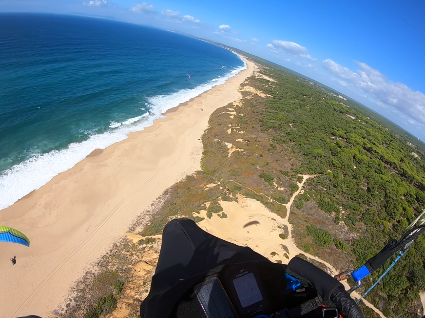 Wide aerial view of Praia das Bicas — long Atlantic beach and coastal cliffs from above